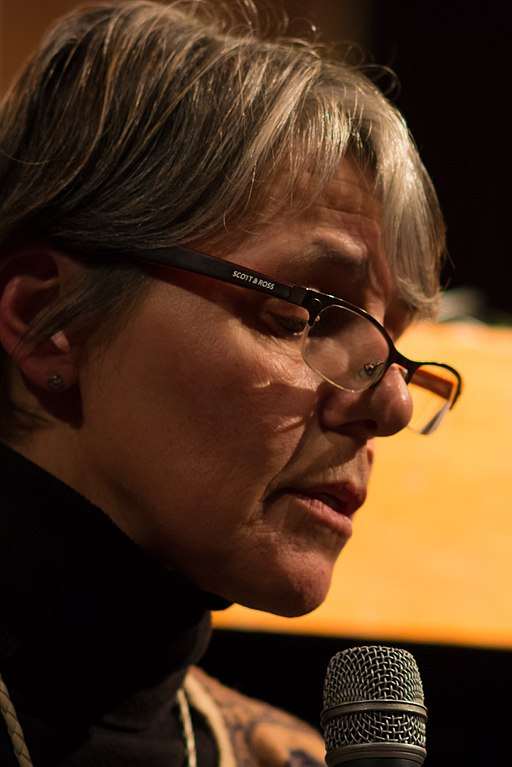 Mariana Mota portrait, speaking with a microphone.